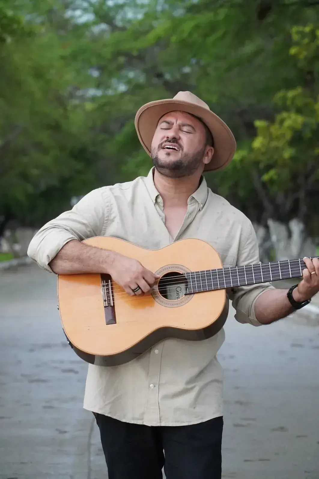 Luis Fabián con sombrero, cantando con su guitarra
