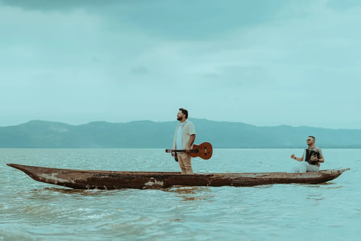 Luis Fabián con su guitarra en una canoa sobre el agua